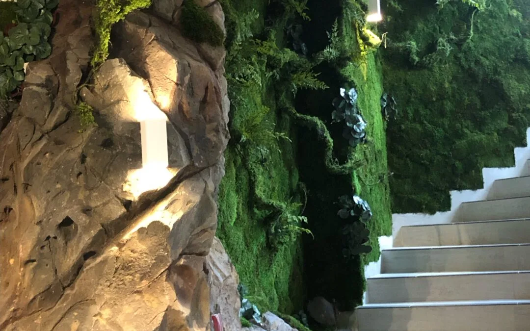 Création d’un mur végétal artificiel avec faux rocher dans un escalier pour une ambiance de forêt.